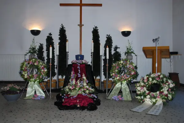 Blumenkränze und Kerzen in der Trauerhalle