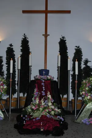 Blick auf das Kreuz und den Blumenschmuck in der Trauerhalle